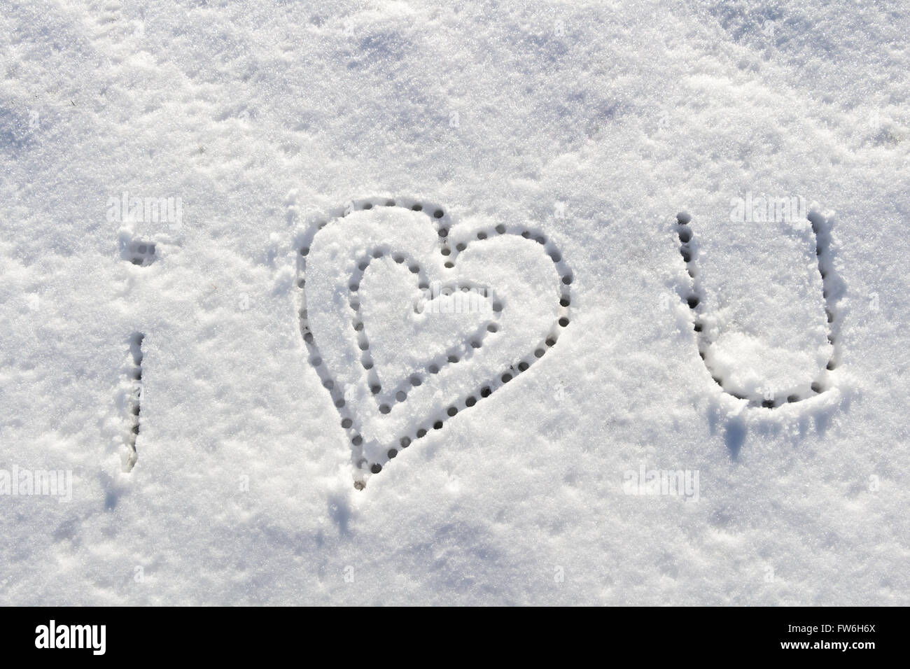 I love you with heart sign writing on the snow. Stock Photo