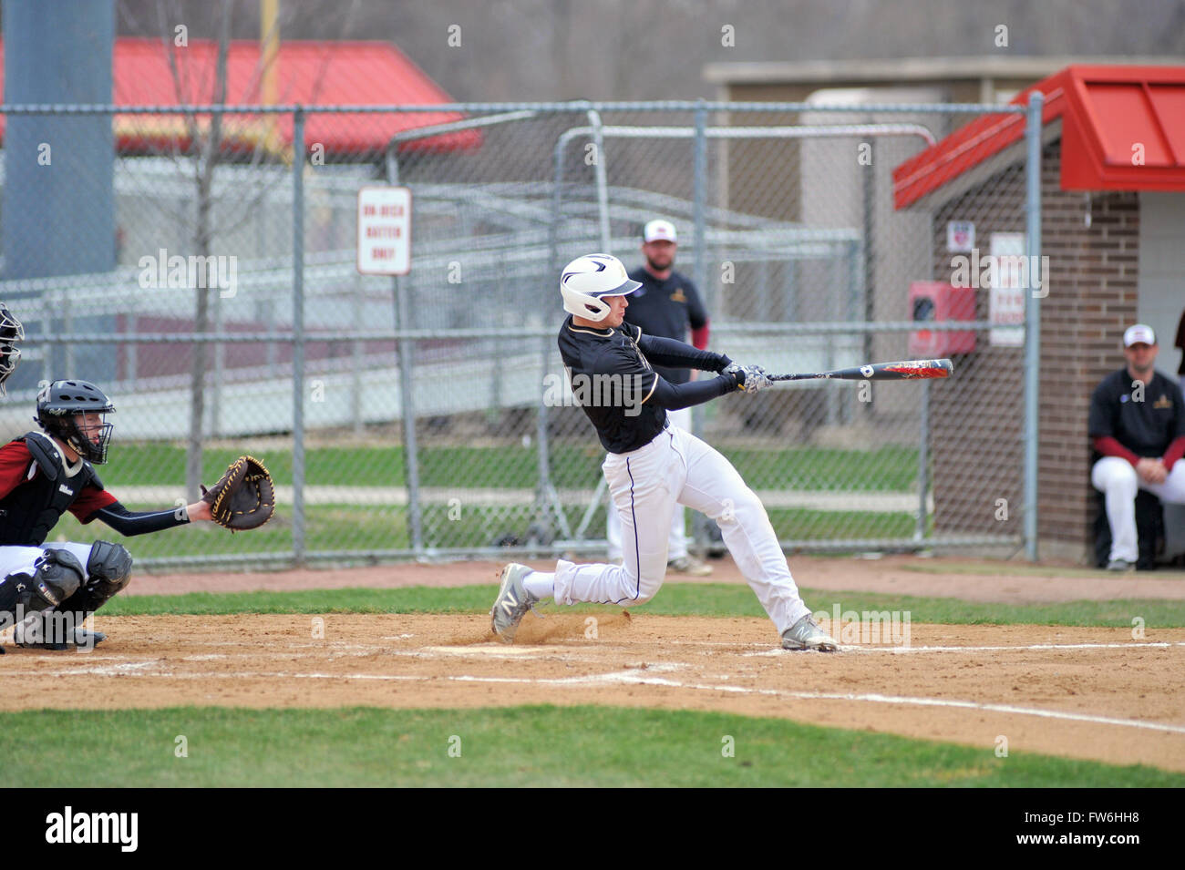 A high school hitter following through on a swing that produced a first inning two-run home run. USA. Stock Photo