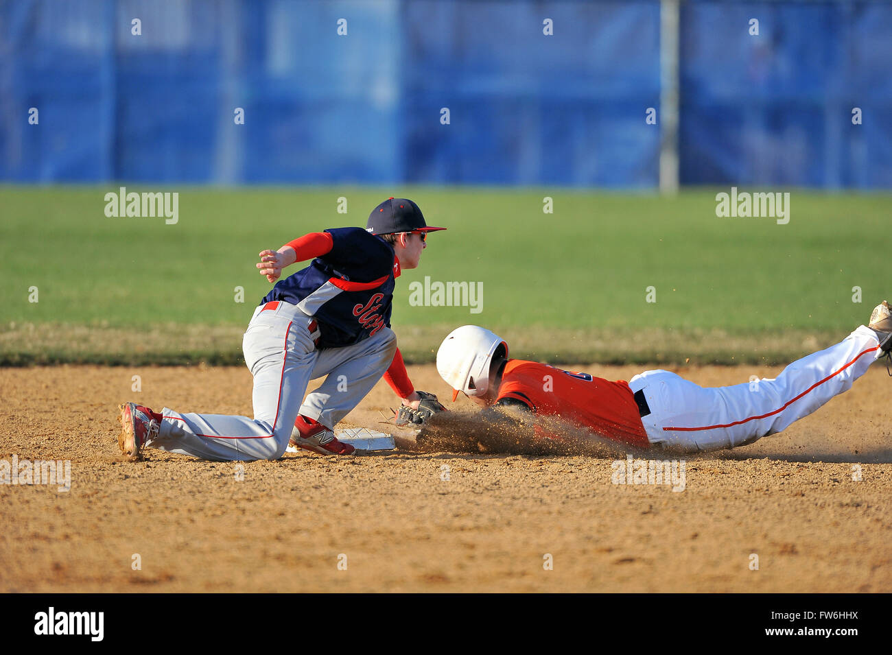 A second baseman tagging out a head-first diving opponent who had tried to steal second base in a high school baseball game. USA. Stock Photo