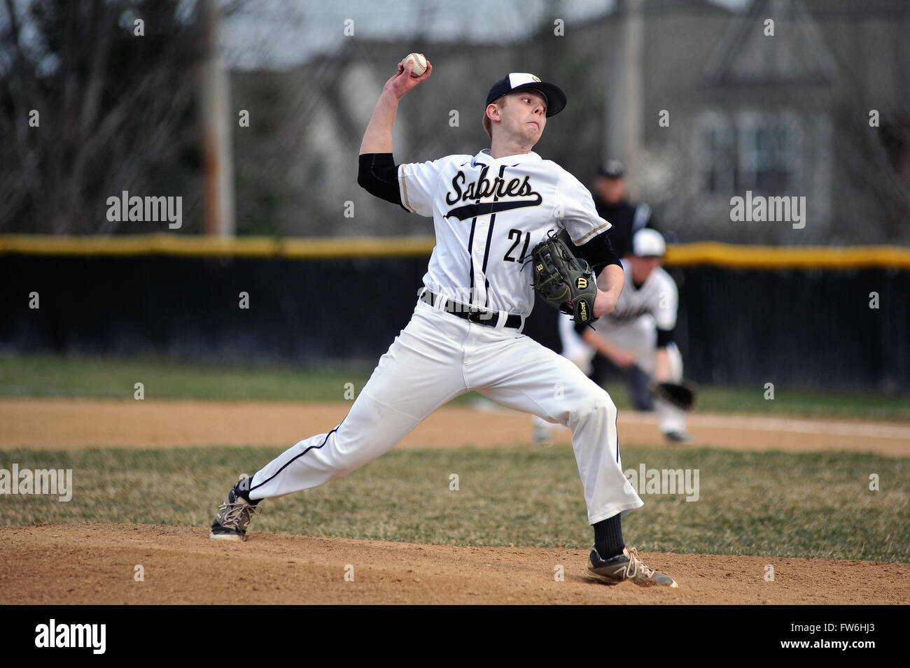 High school pitcher delivering a pitch during his start in an early