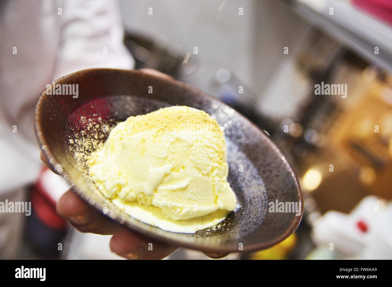 Chef is holding a bowl of vanilla ice cream dessert Stock Photo