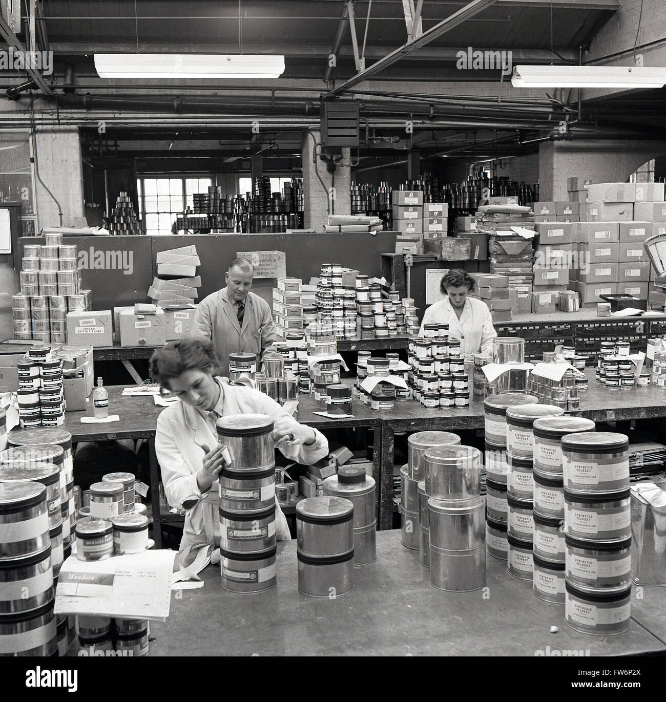 1950s historical, despatch dept, putting labels on tins of paint Stock ...