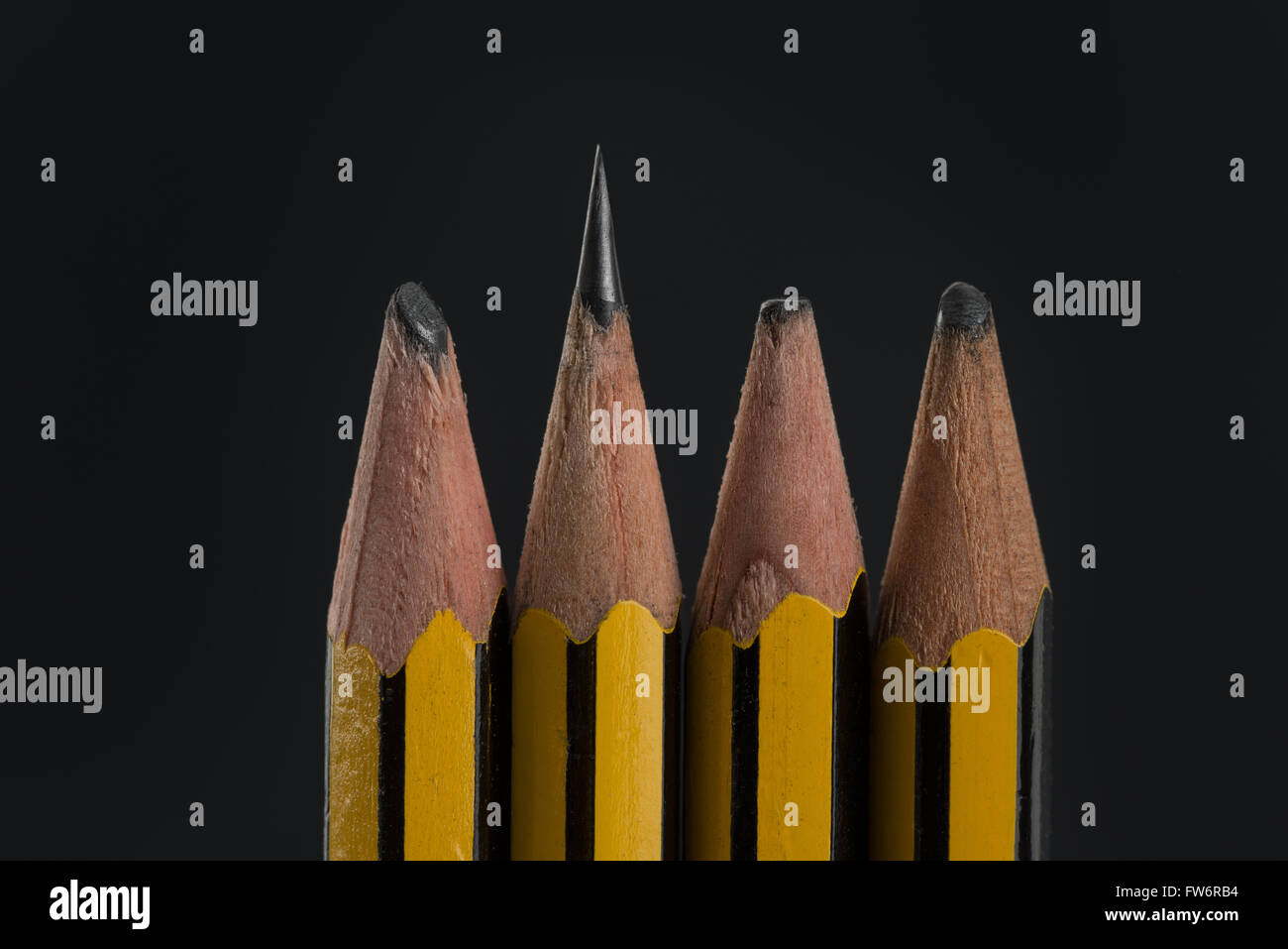 sharp and blunt pencils sigh of hard work or lazy worn pencil lead aligned in a row standing up alert Stock Photo