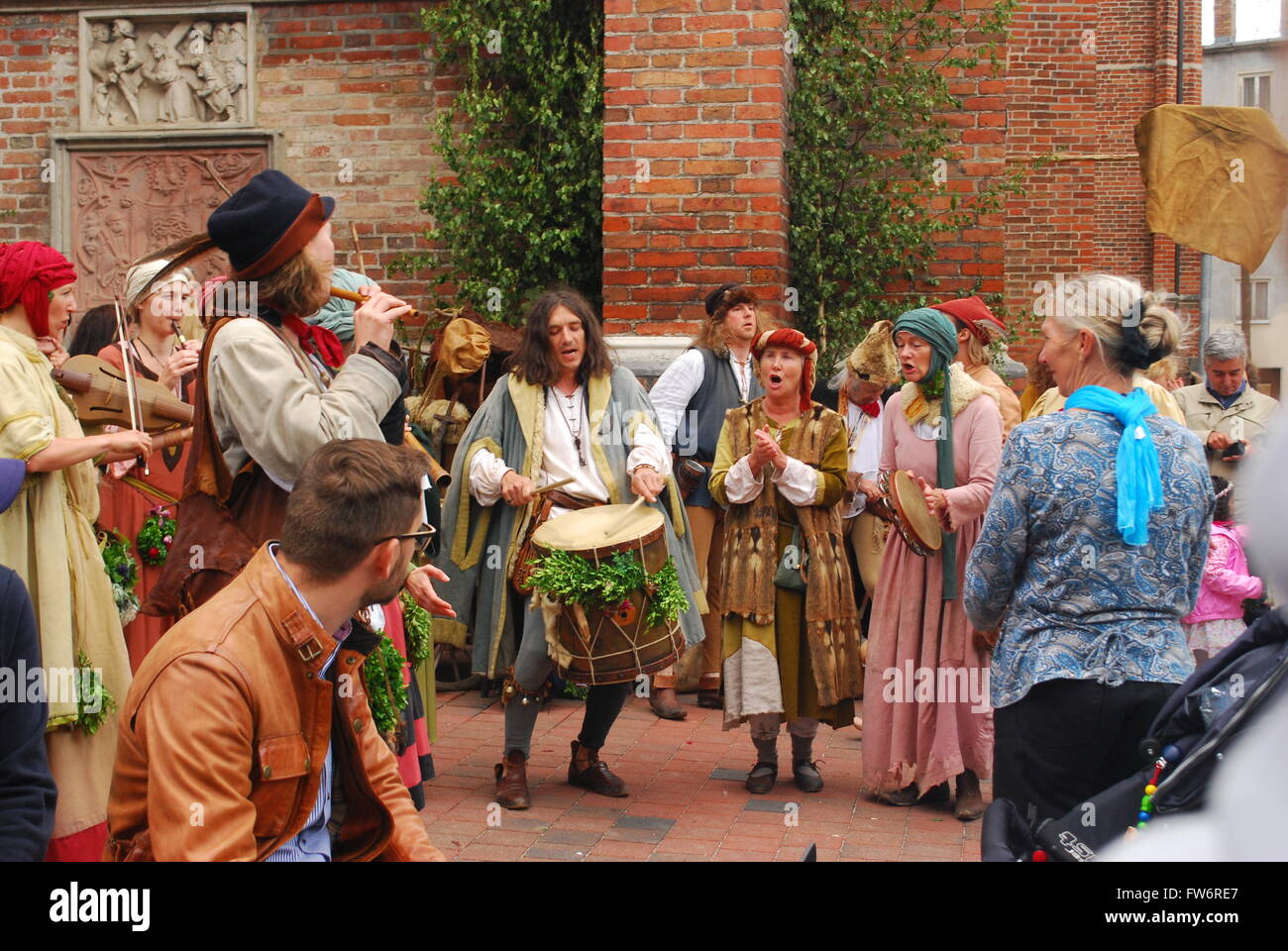 A group of people dressed in medieval costumes play music during the