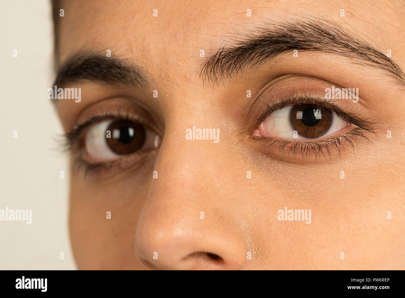 long eyelashes and dark hazel brown eyes of young lady looking seeing into the soul Stock Photo