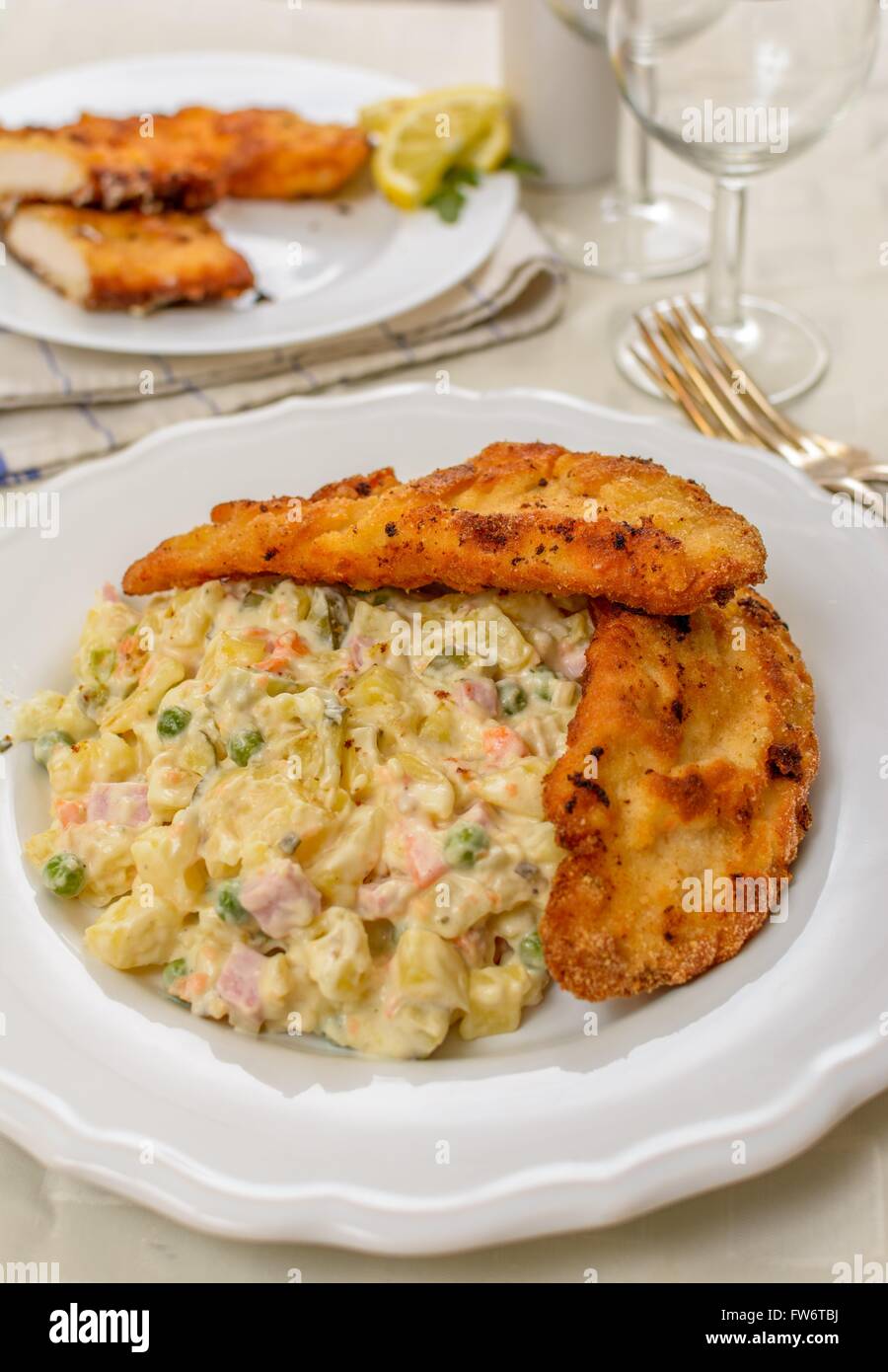 Czech traditional schnitzel with potato and vegetables salad on white ...