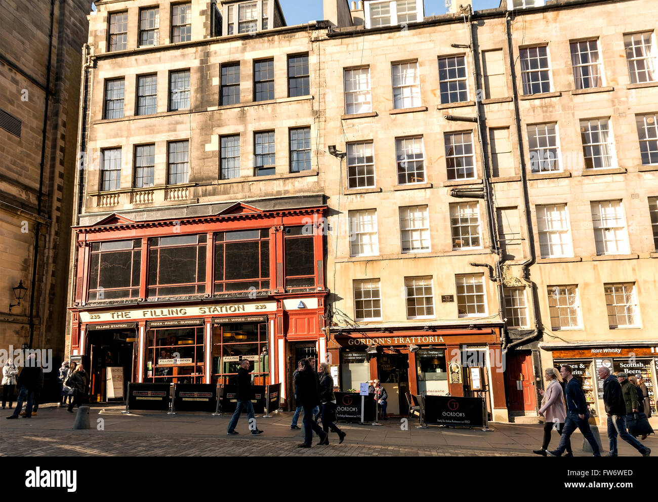 Beneath old town apartments on the Royal Mile in Edinburgh are the Filling Station American Restaurant and Gordon's Trattoria. Stock Photo