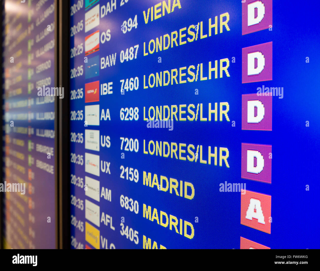 Electronic annunciator panel at an airport showing flights to London and Madrid ready for boarding Stock Photo