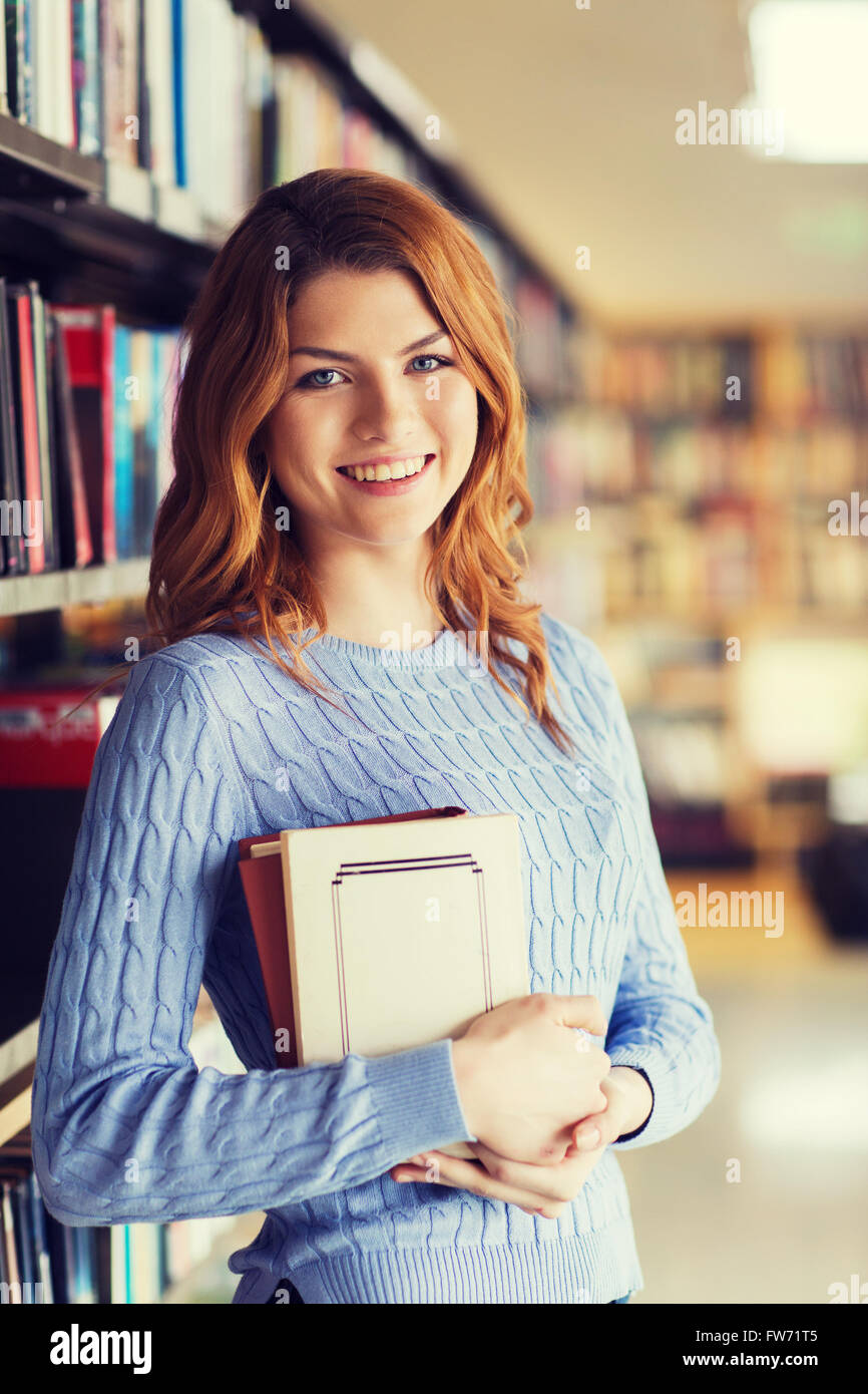 happy student girl or woman with book in library Stock Photo - Alamy