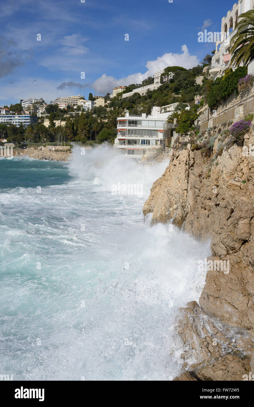 Heavy winter surf breaking on a limestone cliff and quite close to an apartment building. Nice, Alpes-Maritimes, French Riviera, France. Stock Photo