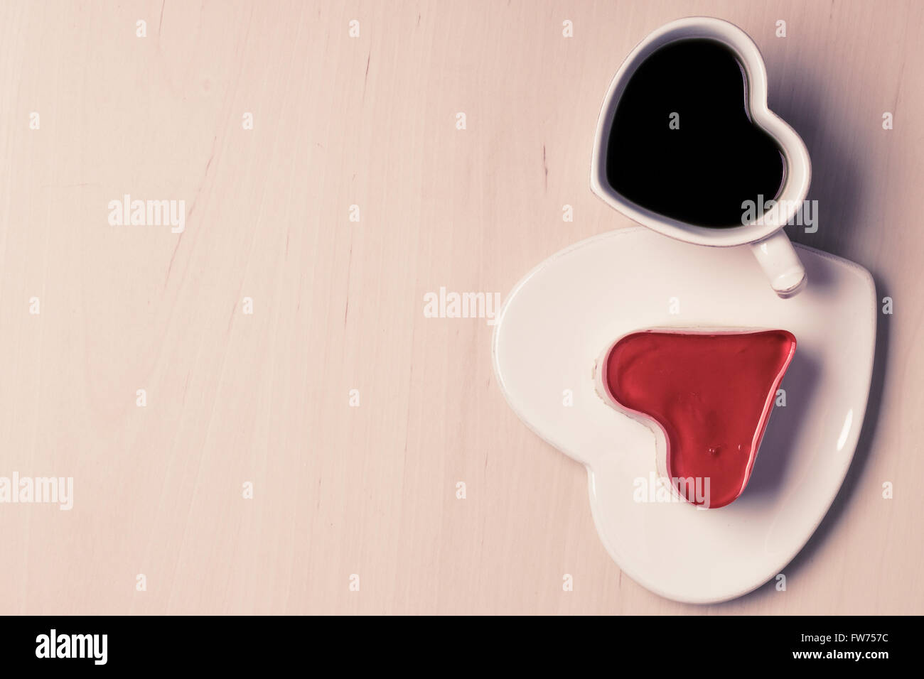 Heart shaped coffee cup and jelly cake on wooden surface, top view copy space for text Stock Photo
