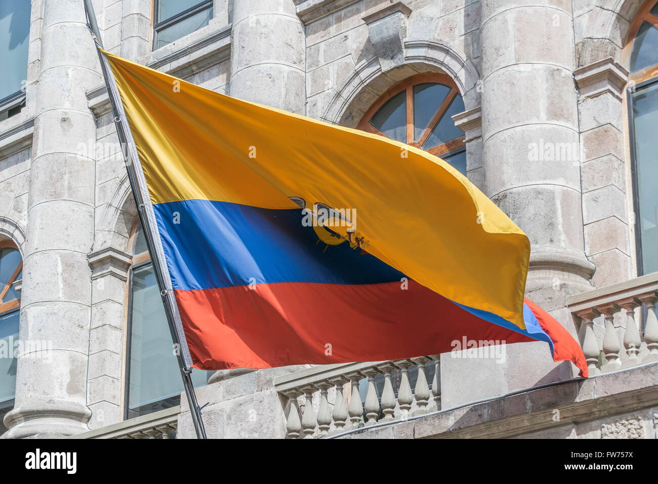 Low angle view of big ecuador flag flying against classical style building at the historic center of Quito, Ecuador. Stock Photo