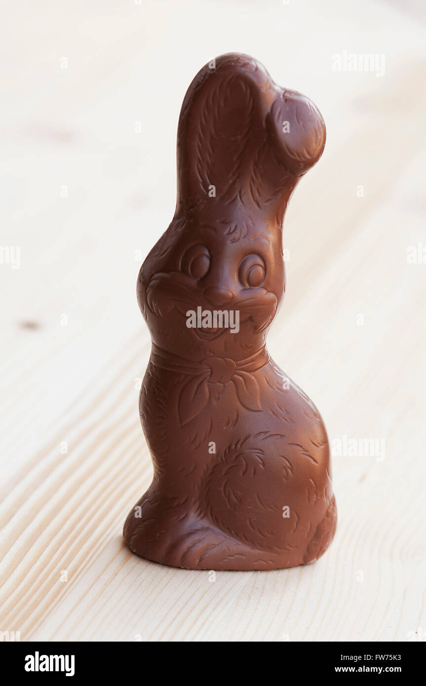 Unwrapped chocholate Easter Bunny on a wooden table Stock Photo