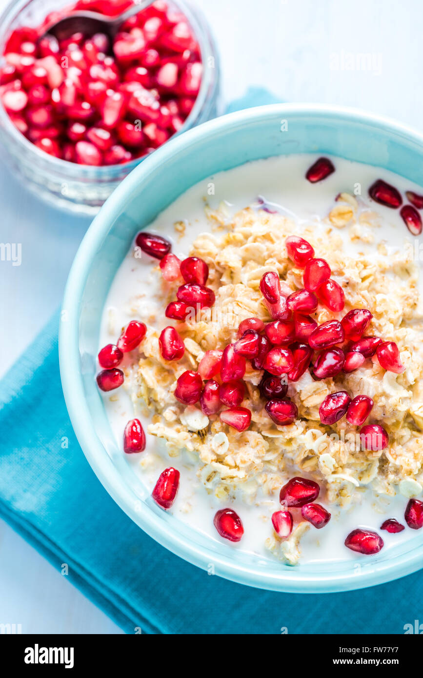 Homemade porridge with pomegranate seeds, overhead on table with space for recipe or text. Bright pastel colors.Summer filing, w Stock Photo