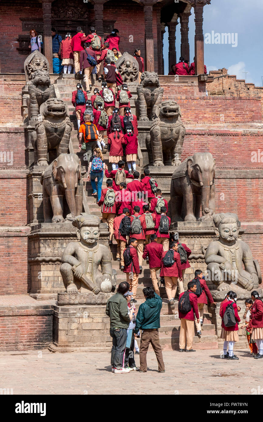 Bhaktapur, Nepal.  Nepalese Students in Uniform Visiting the Nyatapola Temple.  Guardians Line the Steps. Stock Photo