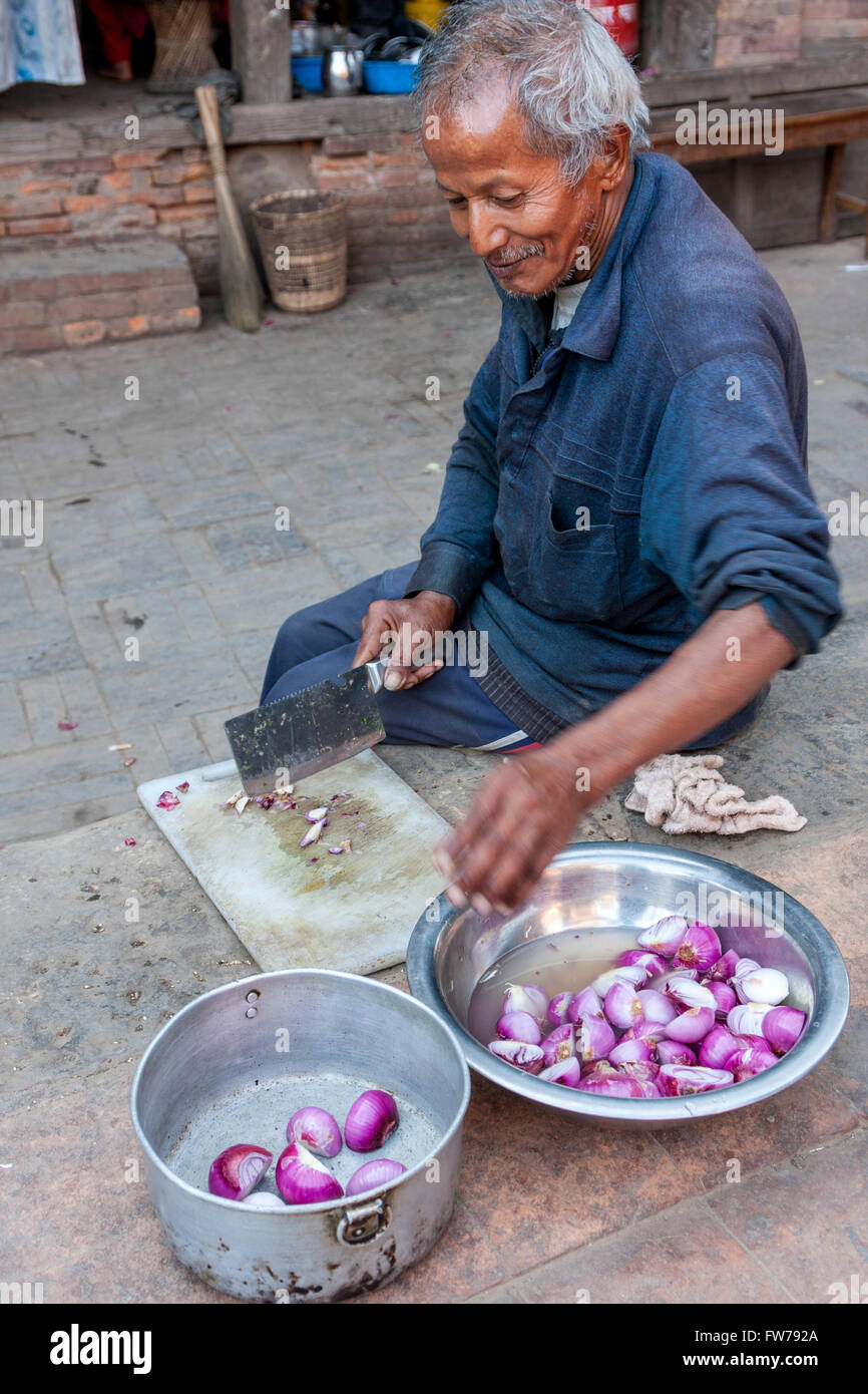 Bhaktapur, Nepal.  Man Cutting Onions. Stock Photo