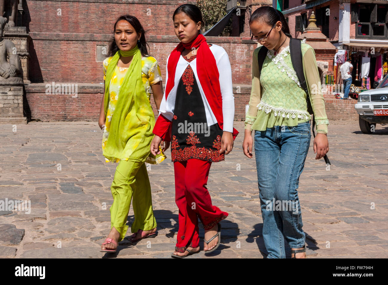 Bhaktapur, Nepal.  Women Walking through Taumadhi Tole Square Blend Traditional and Western Dress Styles. Stock Photo