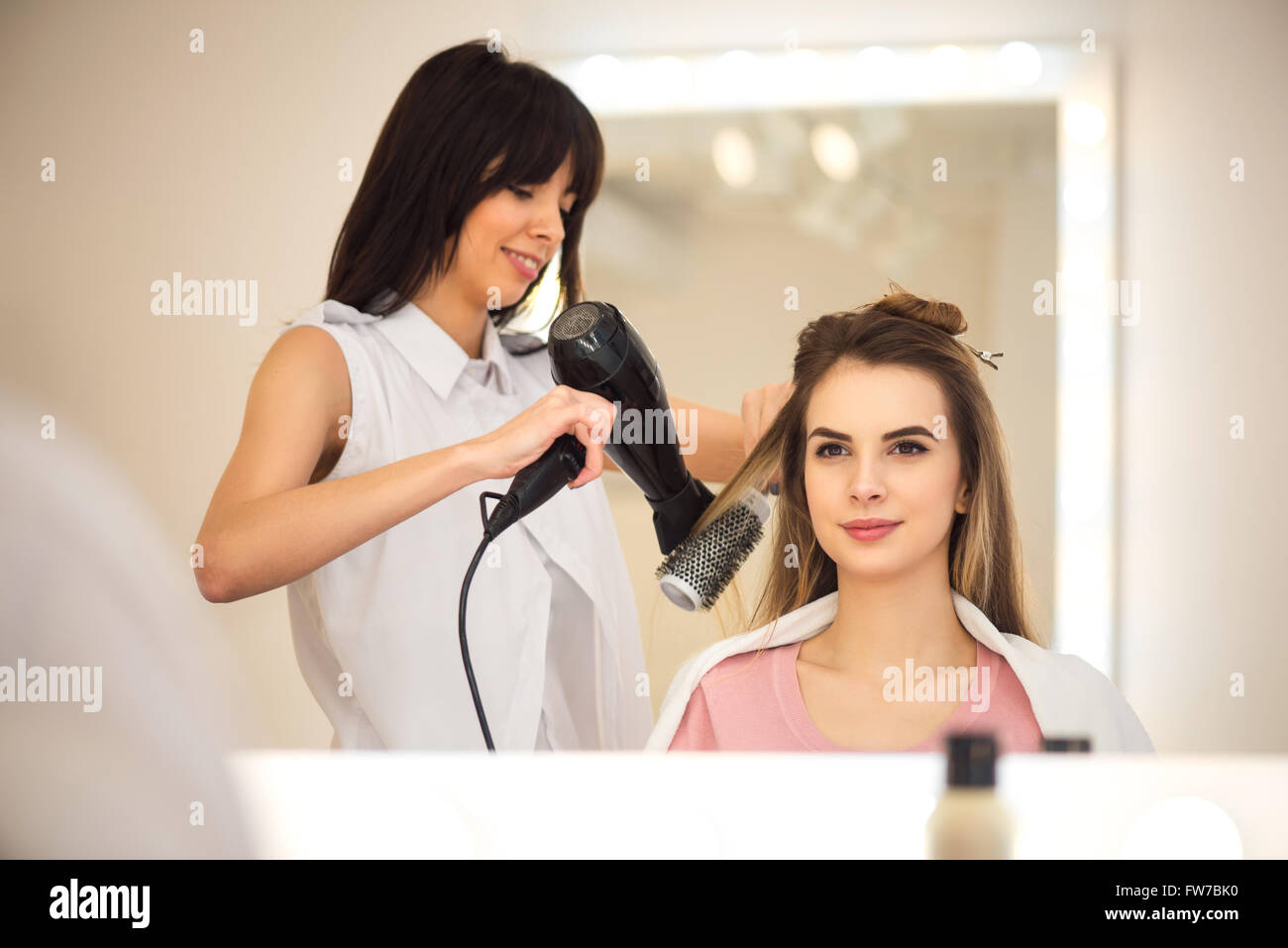 Professional hairdresser drying hair of her client Stock Photo - Alamy