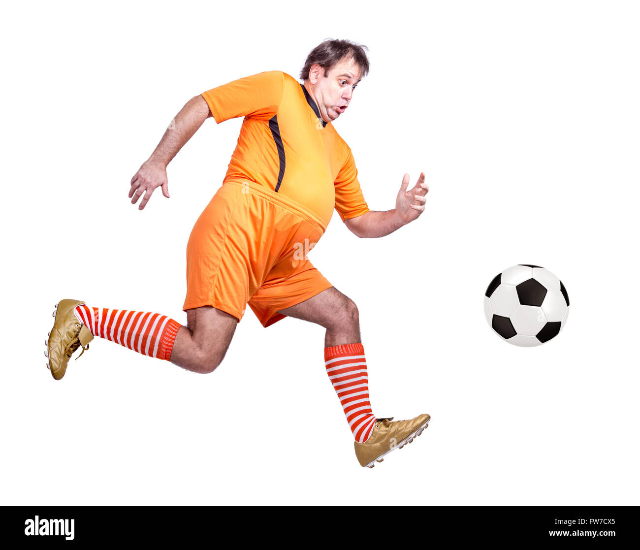 fat soccer player kicking the ball isolated on a white background Stock Photo