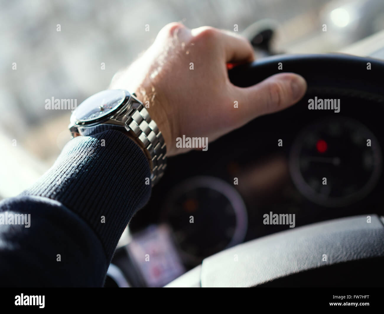 Close-up of man's hand on steering wheel. Shallow depth of field. Stock Photo