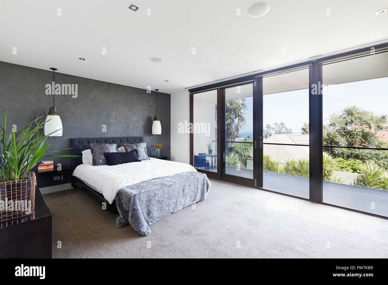 Spacious interior of designer master bedroom in luxury contemporary Australian home Stock Photo