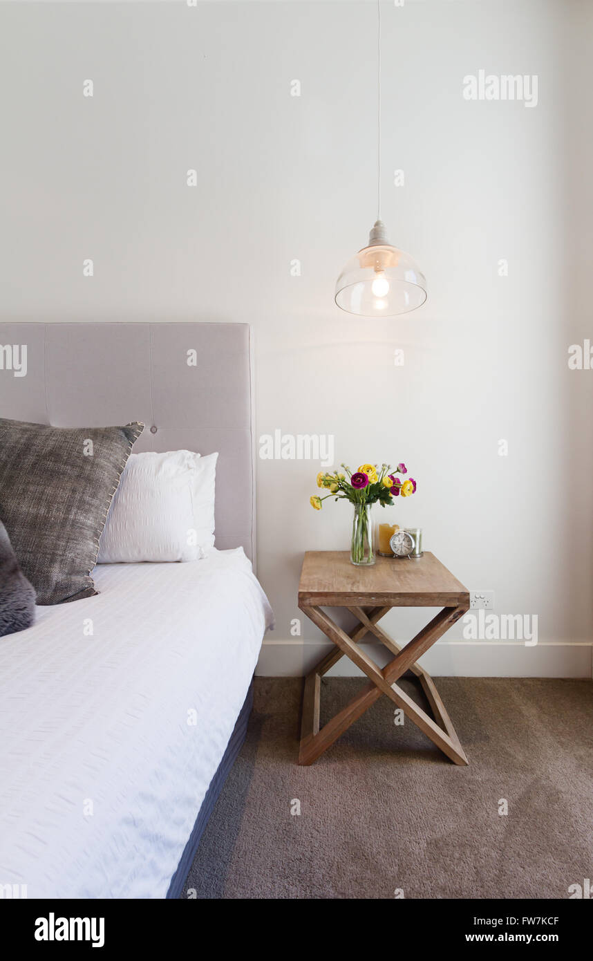 Hamptons styled bedside table with hanging pendant light in luxury home interior Stock Photo