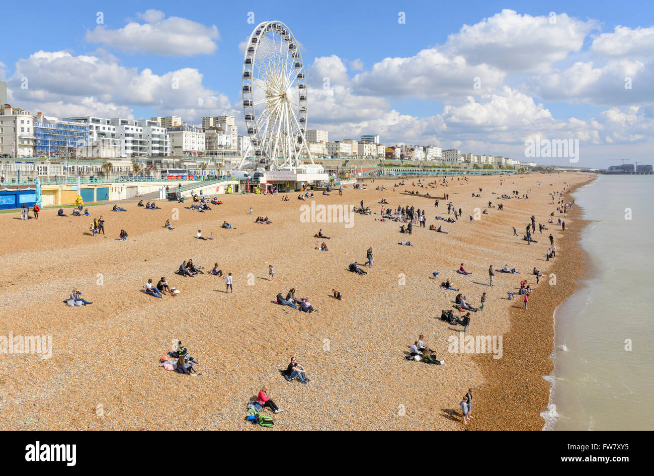 People on the Brighton beach on a sunny day in early Spring, in Brighton, East Sussex, England, UK. Stock Photo