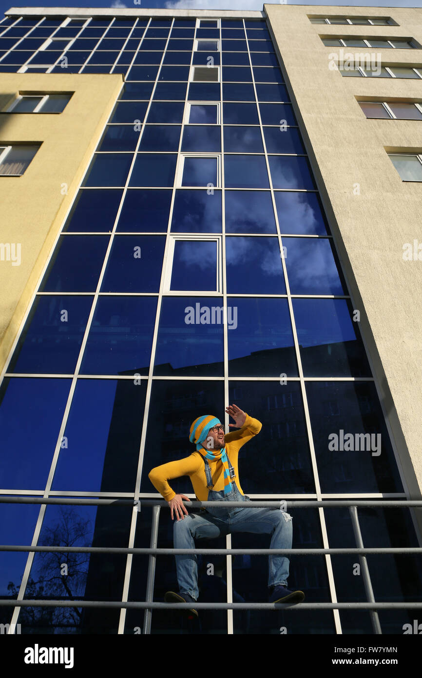 a young man in overalls on background glassed building Stock Photo