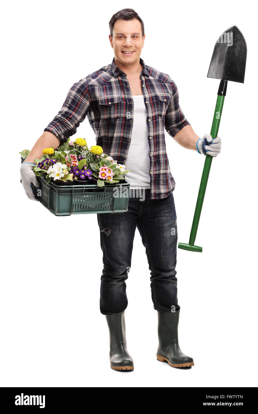 Full length portrait of a young gardener holding a shovel and a crate