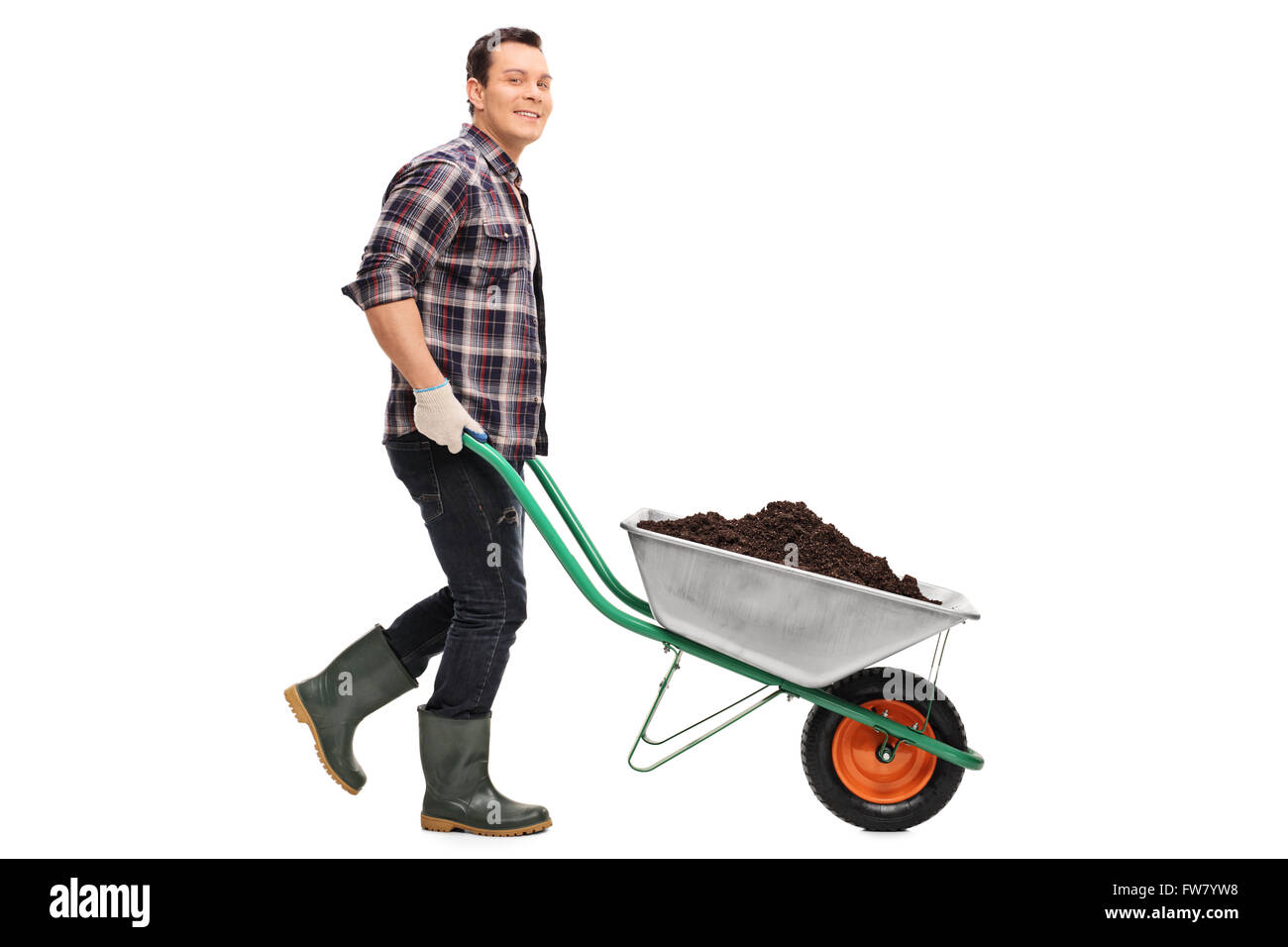 Full length portrait of a young gardener pushing a wheelbarrow full of dirt isolated on white background Stock Photo