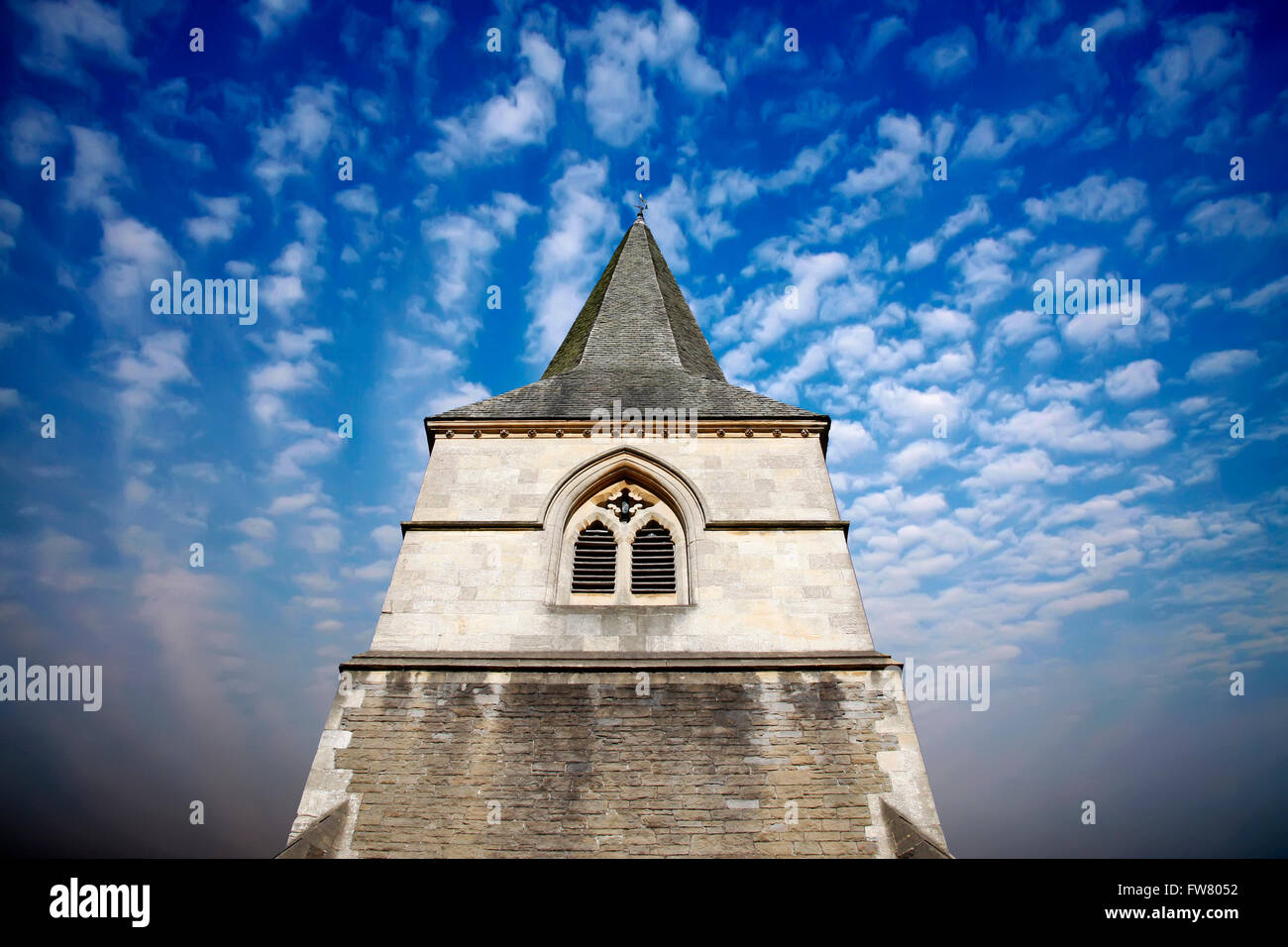 Church spire against a dramatic blue sky Stock Photo