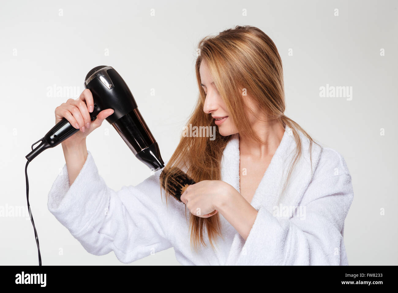 Young woman drying her hair isolated on a white background Stock Photo ...