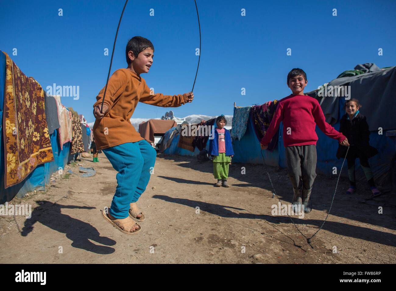 children jumping rope in a refugee camp in Northern Iraq Stock Photo