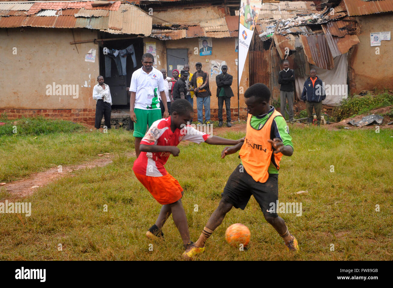 Kampala, Uganda. 01st Apr, 2016. Former Arsenal FC striker and Nigerian international Nwankwo Kanu watches budding football players playing in a slum in the Ugandan capital city, Kampala. Kanu was in a working visit to the East African country as an ambassador of Chinese pay TV StarTimes. Credit:  Samson Opus/Alamy Live News Stock Photo