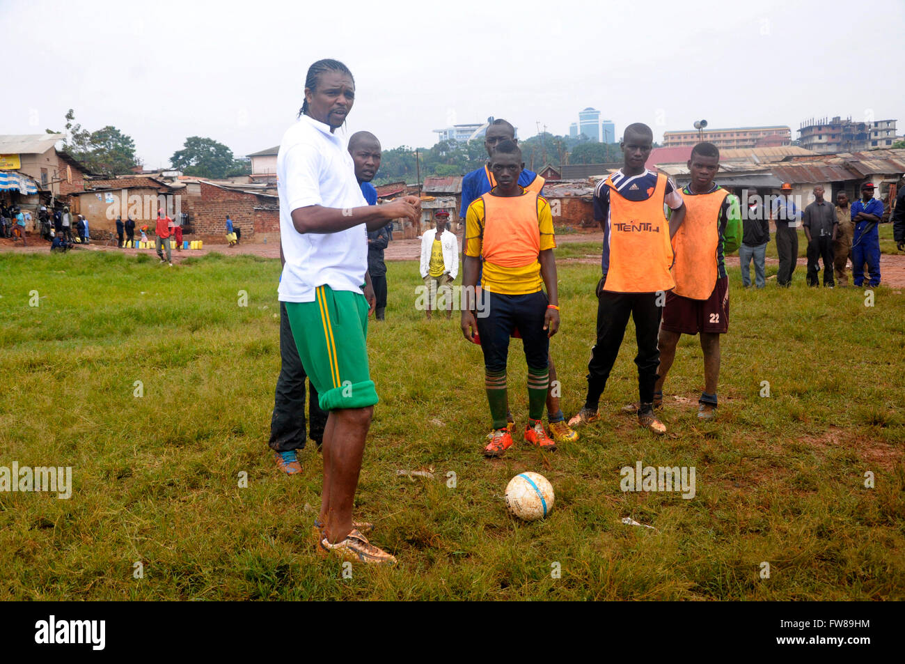 Kampala, Uganda. 01st Apr, 2016. Former Arsenal FC striker and Nigerian international Nwankwo Kanu gives tips to budding football players in a slum in the Ugandan capital city, Kampala. Kanu was in a working visit to the East African country as an ambassador of Chinese pay TV StarTimes. Credit:  Samson Opus/Alamy Live News Stock Photo