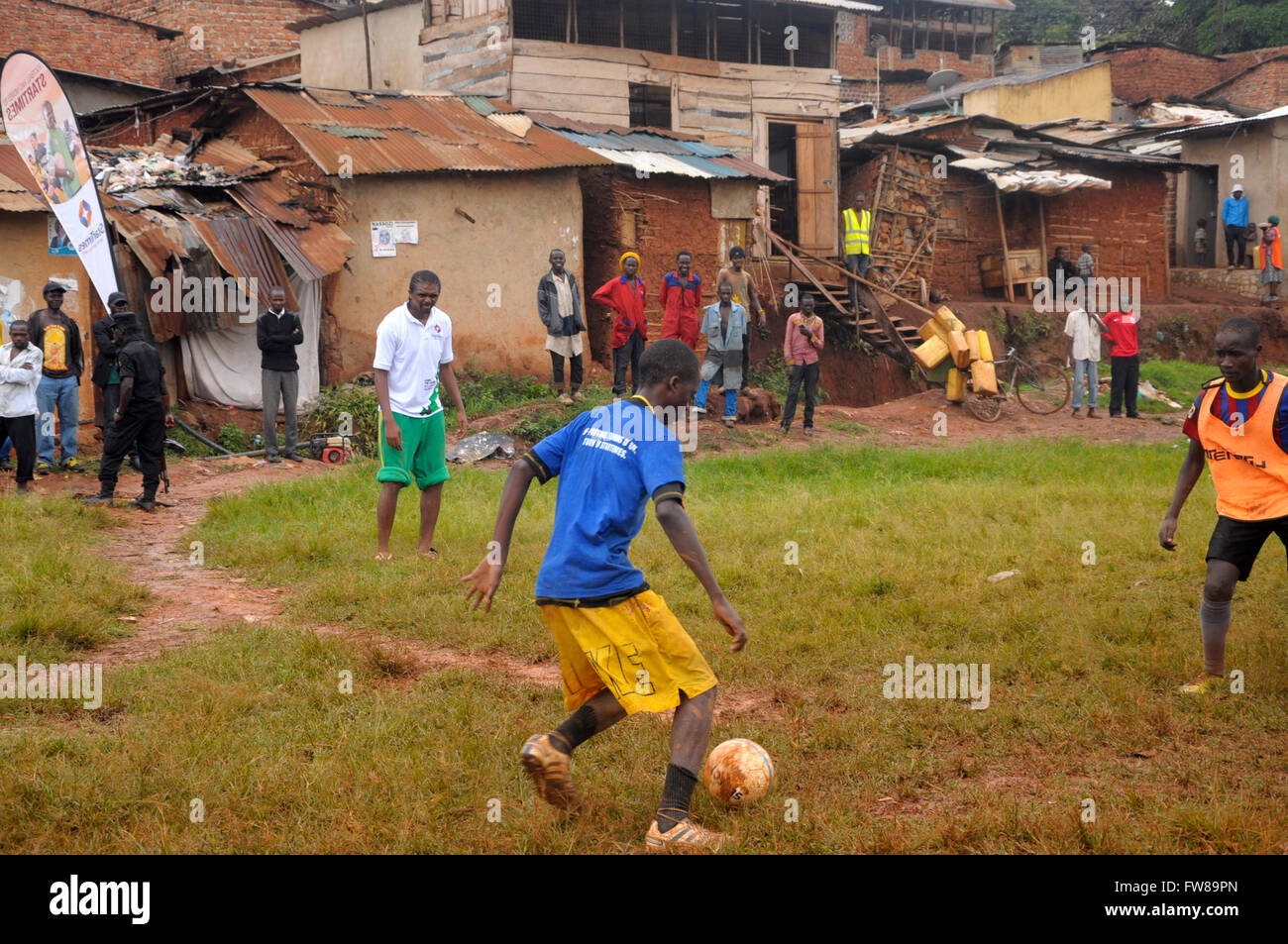 Kampala, Uganda. 01st Apr, 2016. Former Arsenal FC striker and Nigerian international Nwako Kanu watches budding football players playing in a slum in the Ugandan capital city, Kampala. Kanu was in a working visit to the East African country as an ambassador of Chinese pay TV StarTimes. Credit:  Samson Opus/Alamy Live News Stock Photo