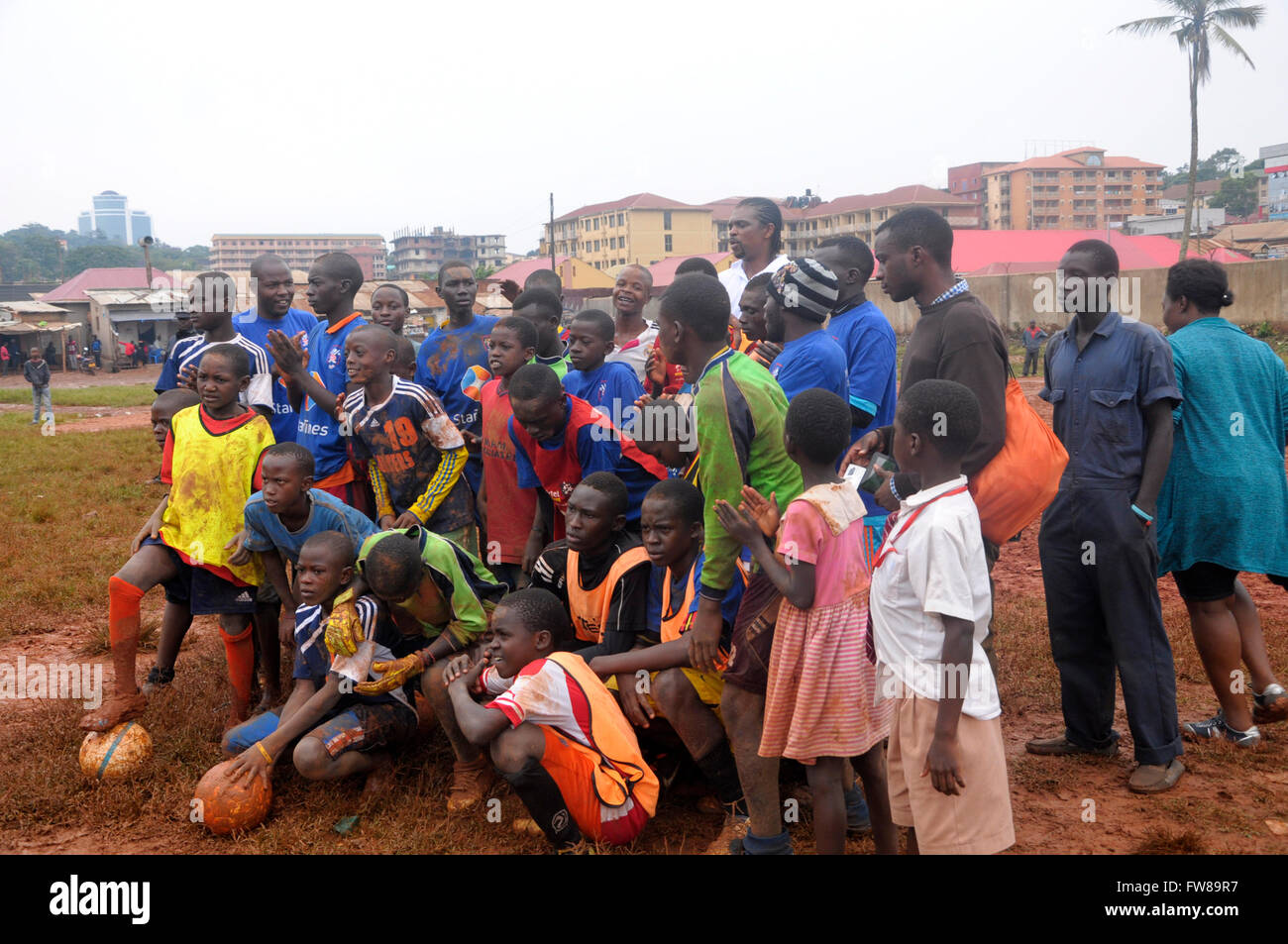 Kampala, Uganda. 01st Apr, 2016. Disadvantaged youth pose for a photo opportunity with former Arsenal FC striker and Nigerian international Nwankwo Kanu after a football training clinic Katanga, a slum in the Ugandan capital city, Kampala. Kanu was in a working visit to the East African country as an ambassador of Chinese pay TV StarTimes. Credit:  Samson Opus/Alamy Live News Stock Photo