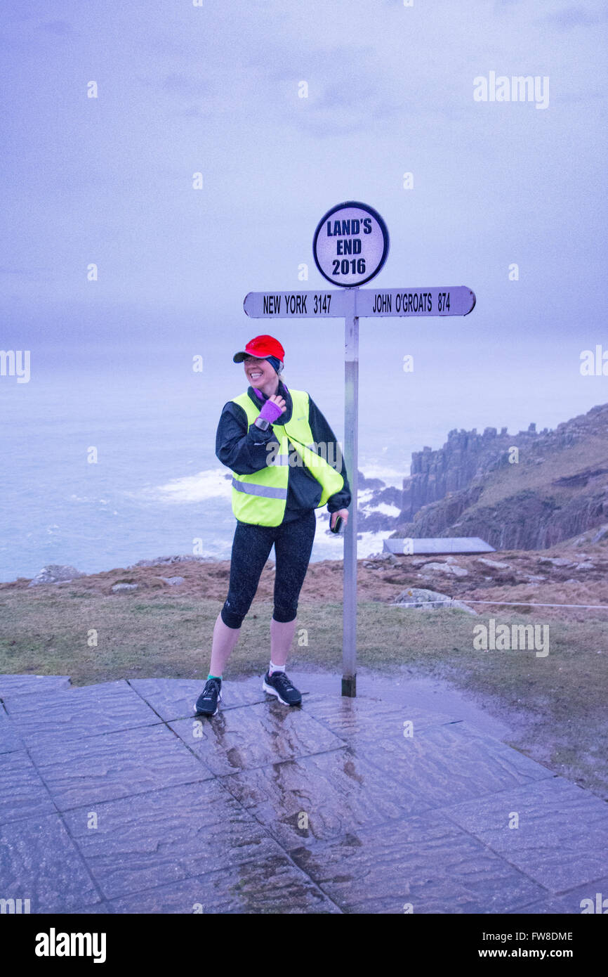 Lands End, Cornwall, UK. 2nd April 2016. Yvie Johnson setting off from a wet Lands End in her attempt to set the world record as  the first female to  run from Lands to John O'Groats and back. She is doing the run to raise money for mental illness charities. Yvie herself was diagnosed with Bipolar disorder in 2015. https://fiercemindevents.wordpress.com/ Credit:  Simon Maycock/Alamy Live News Stock Photo