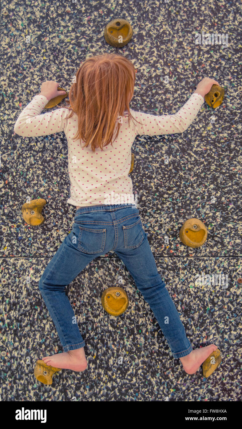 Young Girl On An Inside Climbing Wall Without Ropes Stock Photo
