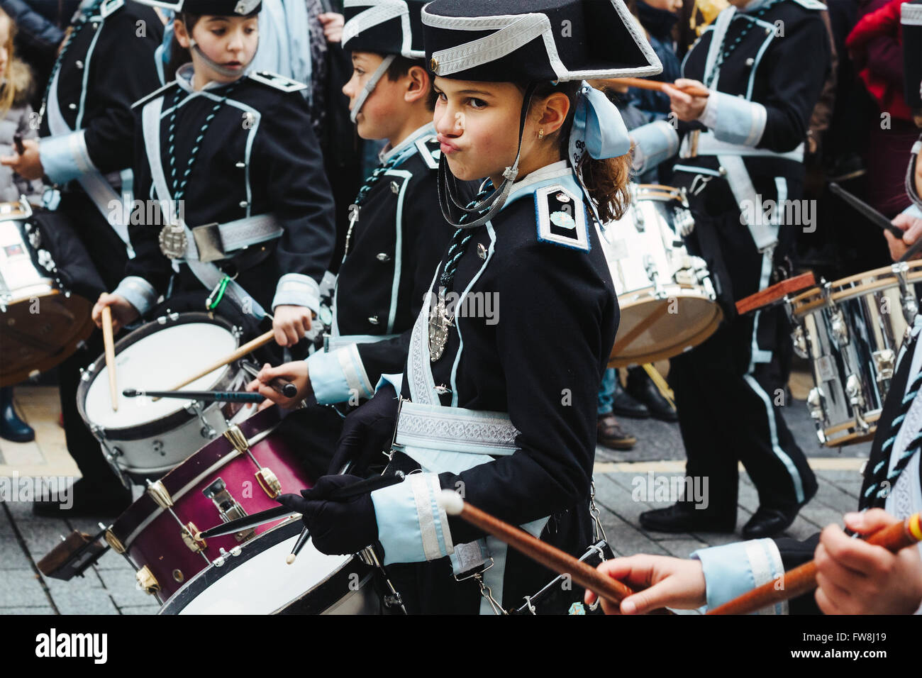Young girl playing drums in a marching band during a Holy Week parade in León. Stock Photo