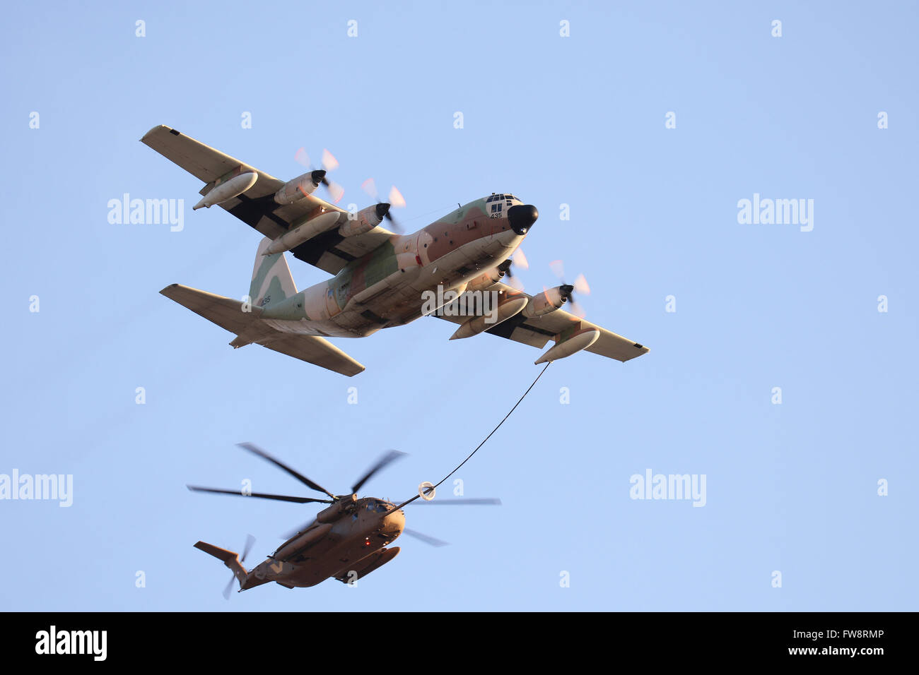 An Israeli Air Force KC-130H Karnaf refuels a CH-53 Yasur assault helicopter over Israel. Stock Photo