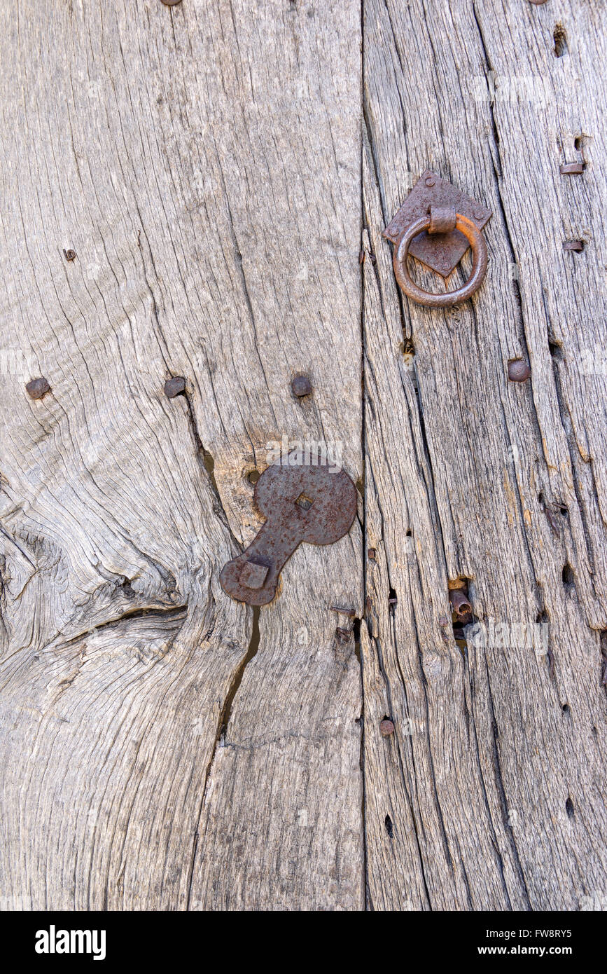 Ancient wood with ring, nails and mounting made of metal. Detail of an ancient door. Stock Photo
