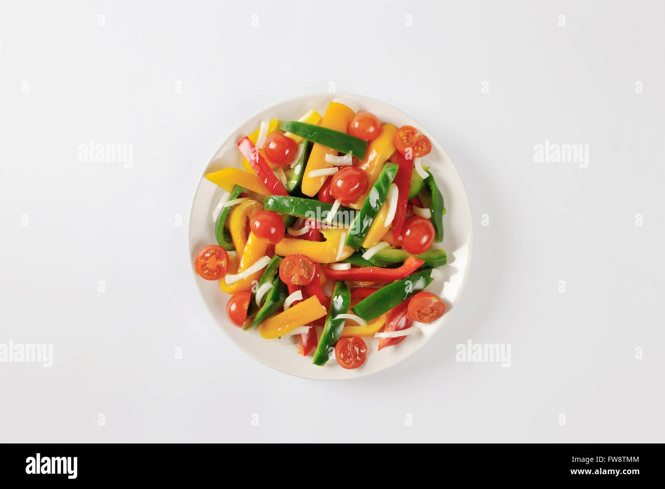 Plate of fresh bell pepper strips and halved cherry tomatoes Stock Photo