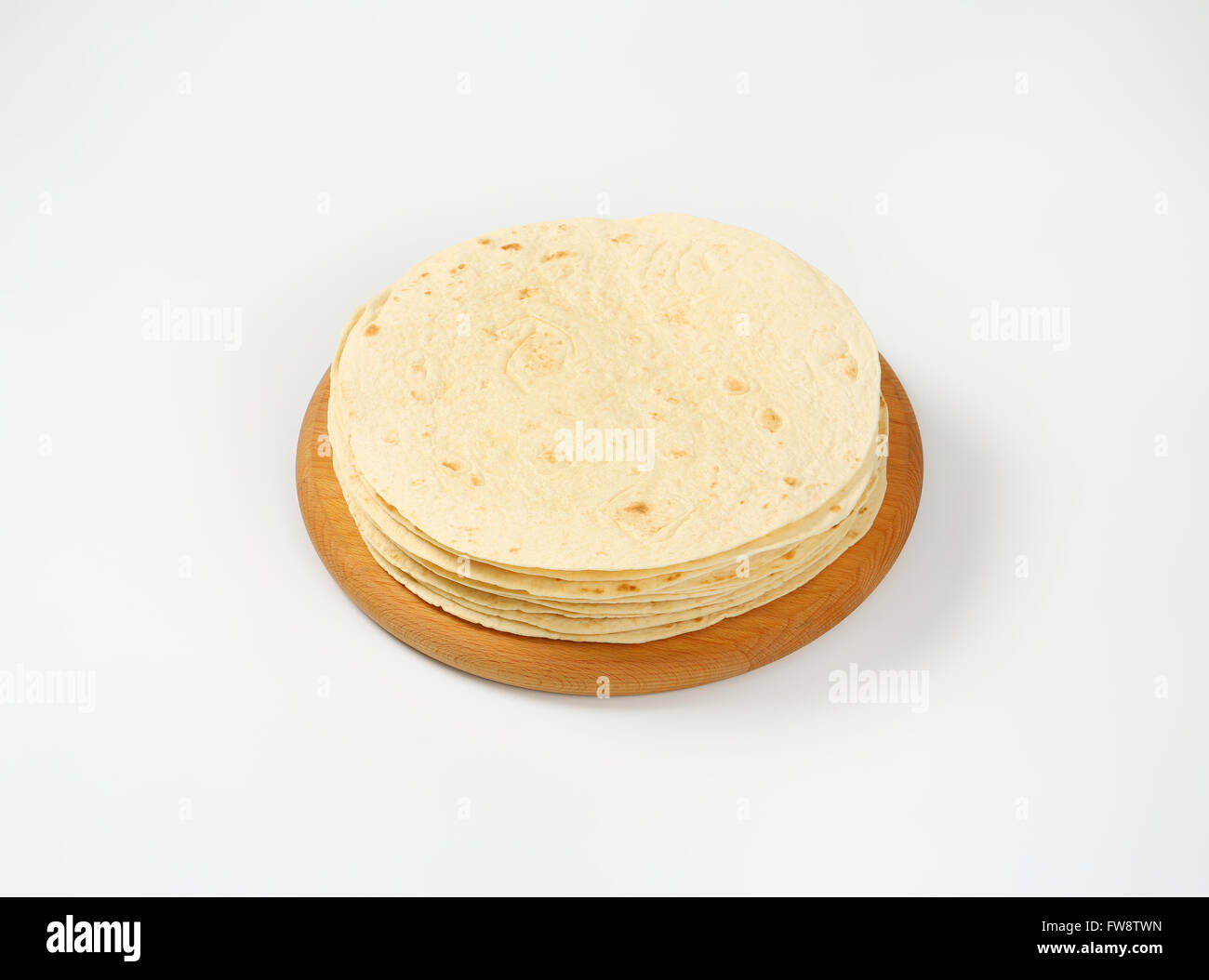 stack of freshly baked tortillas on wooden cutting board Stock Photo