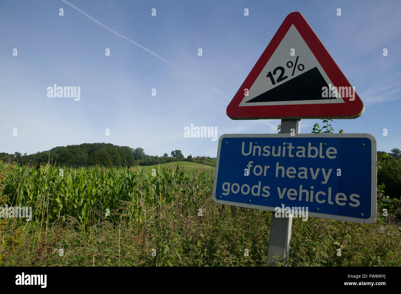 A farm or country track betyween fields and a road sign indicating a ...