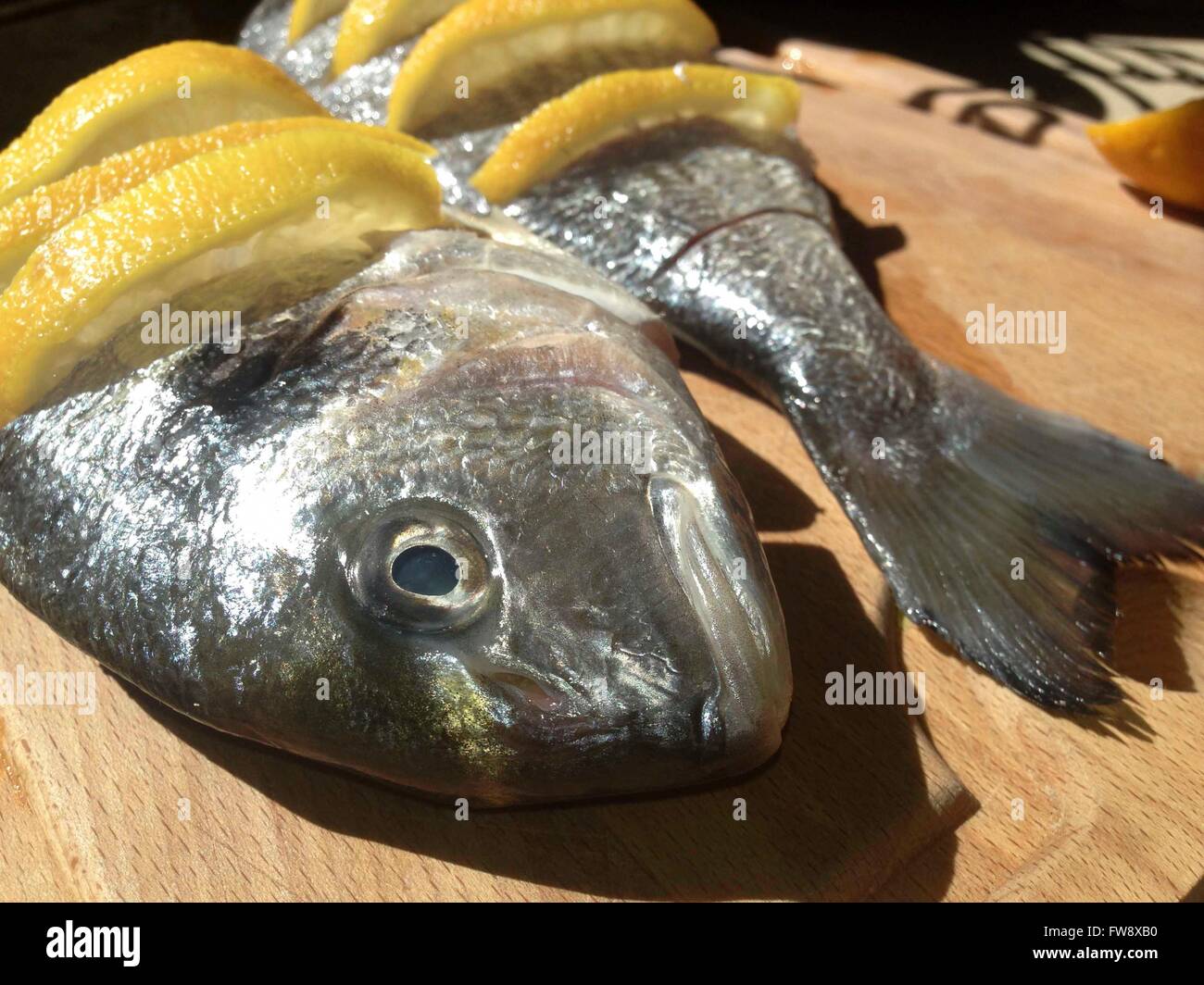 Raw marinated gilt-head bream over cutting board before cooking Stock Photo