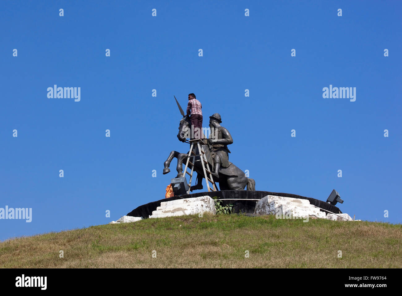 A man and woman cleaning the statue of Bhai Fateh Singh at the Baba