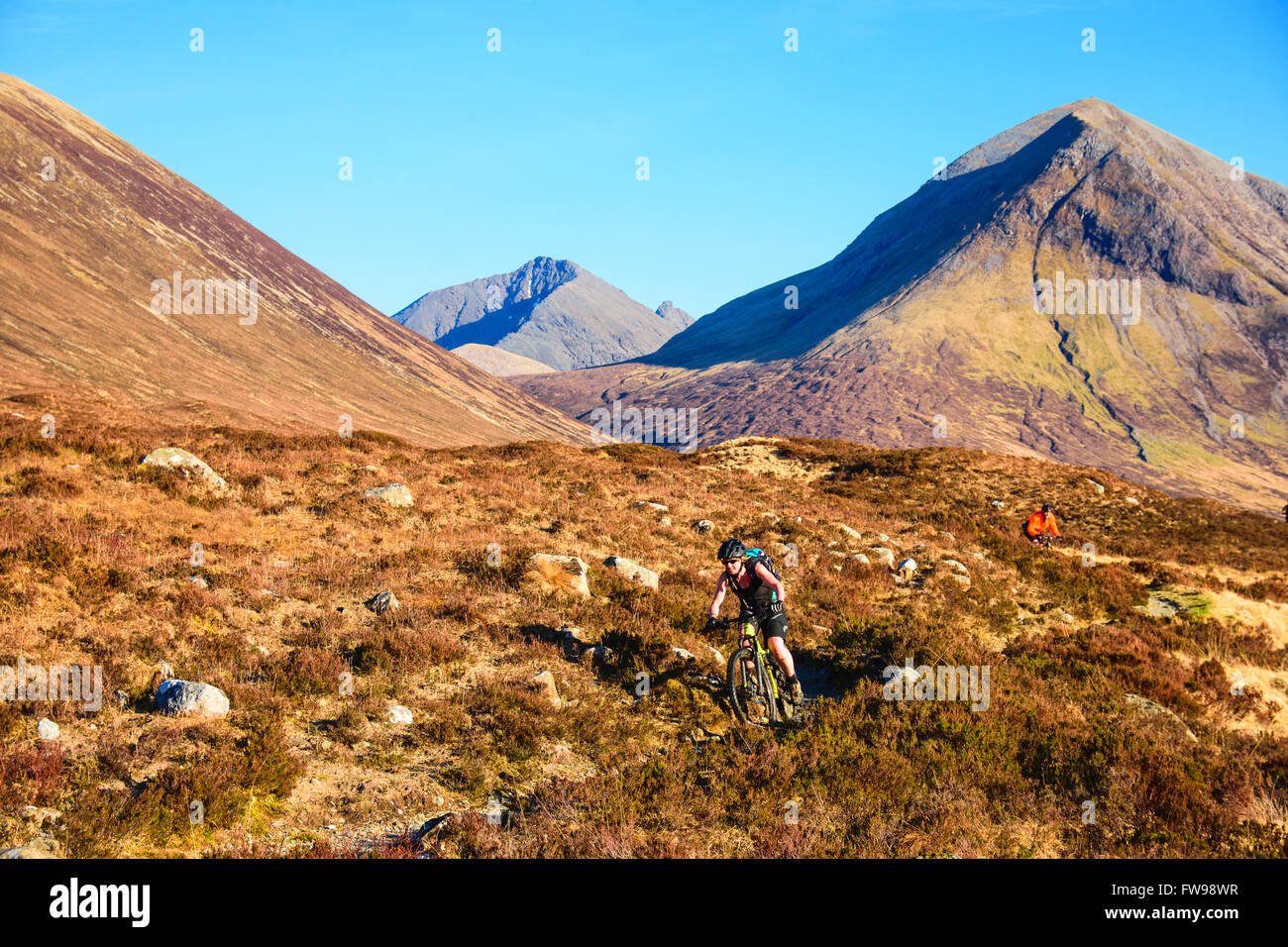 Mountain bikers on the trail from Camasunary to Sligachan Isle of Skye Scotland with Marsco and Blabheinn behind. Stock Photo