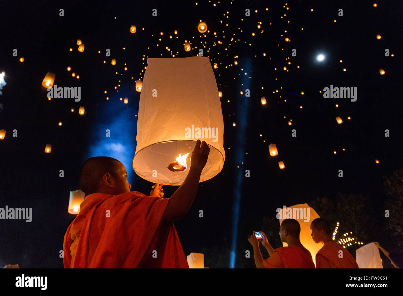 Monk letting sky lantern rise, Loi Kratong or Loy Krathong festival, night sky, Chiang Rai Province, Thailand Stock Photo