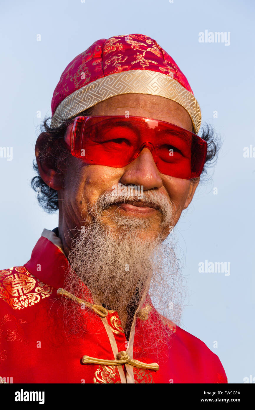 Portrait, old chinese man with red glasses, hat and beard, Chinese New Year, Spring Festival, Chinatown, Bangkok, Thailand Stock Photo